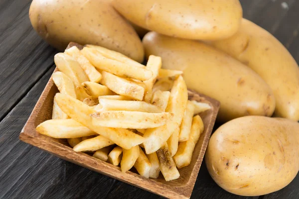 Batatas fritas em fundo de madeira — Fotografia de Stock