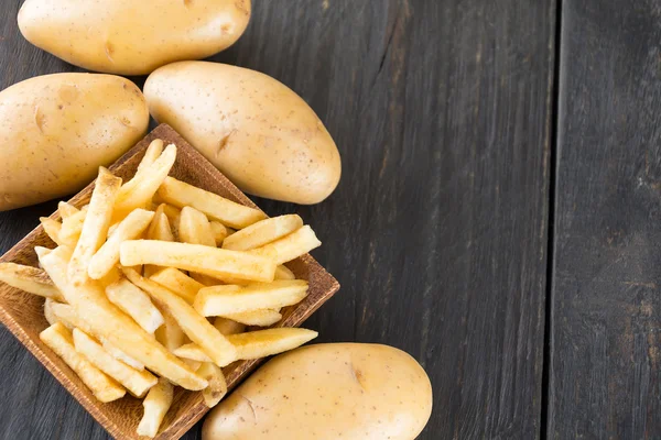 Batatas fritas em fundo de madeira — Fotografia de Stock