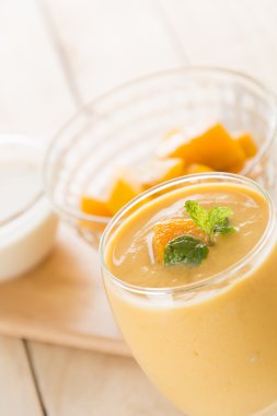 Ahşap arka planda taze mango smoothie.