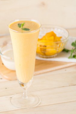 Ahşap arka planda taze mango smoothie.