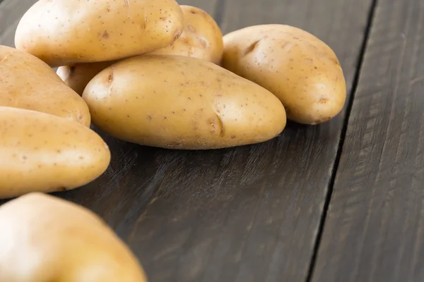 Batatas frescas sobre fundo de madeira — Fotografia de Stock