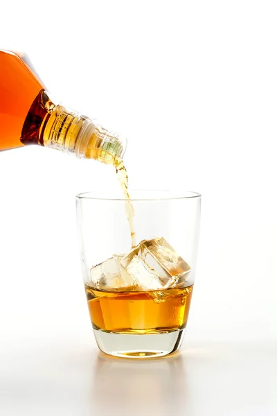 Derramando wisky no fundo branco — Fotografia de Stock