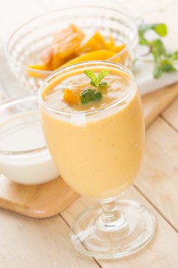 Ahşap arka planda taze mango smoothie.