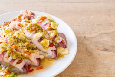 Baharatlı biber ve limon soslu haşlanmış mürekkep balığı veya ahtapot.