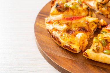 Tahta tepside deniz ürünleri (karides, ahtapot, midye ve yengeç) pizza