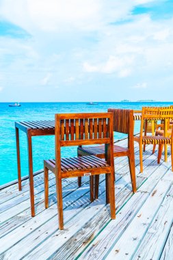 Maldivler deniz manzarası arka plan ile boş açık ahşap masa ve sandalye