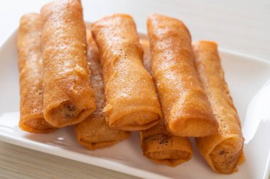 Kızarmış yumurta rulosu ve beyaz tabakta sos.