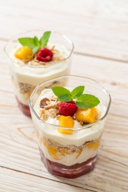Ev yapımı taze mango ve yoğurt ve granola ile taze ahududu. Sağlıklı yemek tarzı.