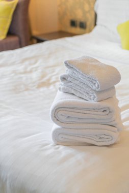 Otel odasında beyaz havlu katlanır.