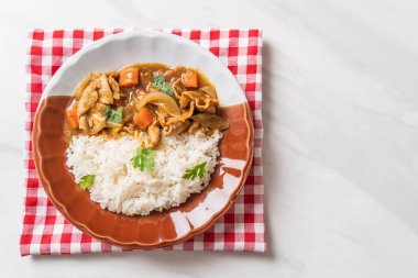 Dilimlenmiş domuz eti, havuç ve soğanlı Japon körili pilavı. Asya usulü.