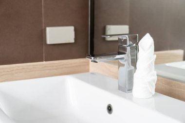 Modern metalik musluğun banyodaki yakın çekimi.