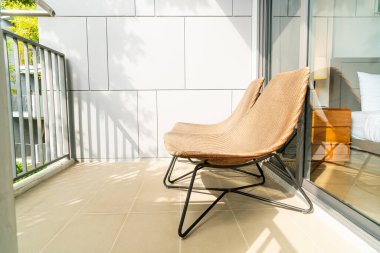 Balkonda boş bir bahçe sandalyesi.