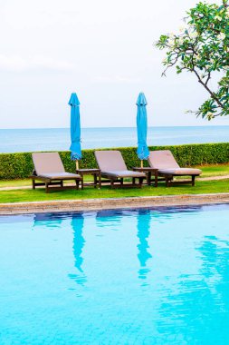 Sandalye havuzu ya da yüzme havuzu etrafında şemsiye olan yatak havuzu