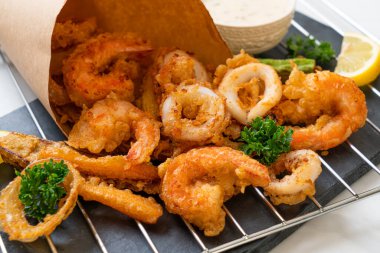 Kızarmış deniz ürünleri (karides ve mürekkep balığı) ve sebze karışımı - sağlıksız gıda tarzı