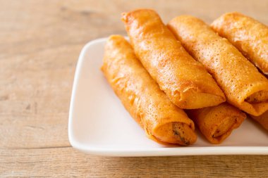 Kızarmış yumurta rulosu ve beyaz tabakta sos.