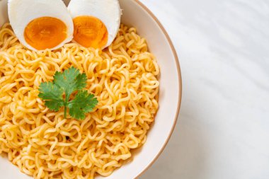 Hazır erişte kasesi ve tuzlu yumurta.