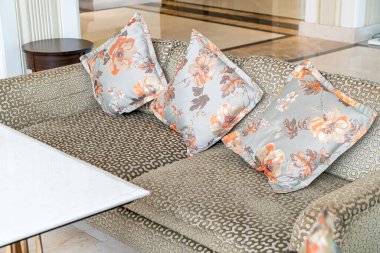 Boş kanepe ve yastıklı sandalye bir odada.