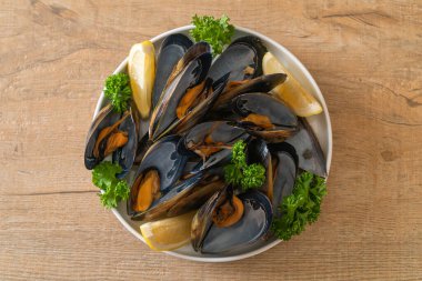 Limonlu bir kasede otlu taze midyeler.