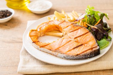 Kızarmış somon bifteği fileto, sebze ve patates kızartması.