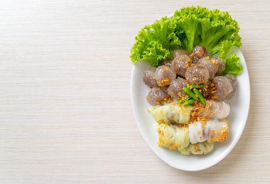 Şeffaf toplara Saku Sai Moo ya da Buharlı Tapioca Köfte Topları ve (Kow Griep Pag Mor) Domuz Buharlı Pirinç Paketleri ya da Haşlanmış Pirinç Kabuklu Mantı denir.