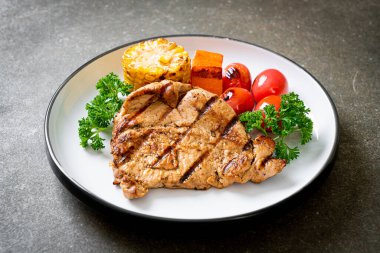 Izgara ve ızgara fileto domuz bifteği, mısır, havuç ve domates.