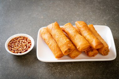 Kızarmış yumurta rulosu ve beyaz tabakta sos.