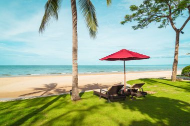 Tatil seyahati konsepti için otel tatil beldesinde deniz manzaralı bir şemsiye ve sandalye.