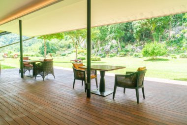 Bahçe sandalyesi ve balkondaki bahçe arka planlı masa.