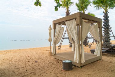 Bulutlu bir günde deniz arka planına sahip sahildeki pavyon - seyahat ve tatil konsepti