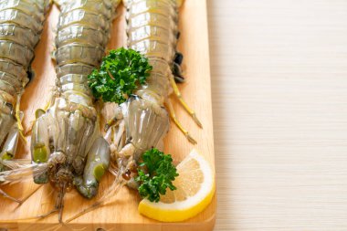 Tahtada limon olan taze peygamber devesi karidesi.