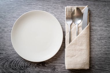 Ahşap zemin üzerinde bıçak, çatal ve kaşık olan boş tabak veya tabak