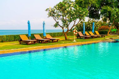 Havuz kenarındaki havuz, havuz, şemsiye, deniz manzaralı havuz tatilleri ve tatil konsepti.
