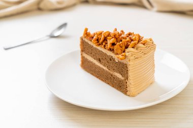 Ev yapımı kahve badem keki beyaz tabakta.