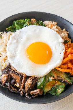 Bibimbap, Kore baharatlı salata pilav ve sahanda yumurta. Geleneksel Kore yemeği tarzı.