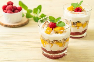 Ev yapımı taze mango ve yoğurt ve granola ile taze ahududu. Sağlıklı yemek tarzı.