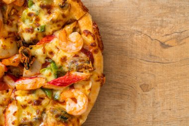 Tahta tepside deniz ürünleri (karides, ahtapot, midye ve yengeç) pizza