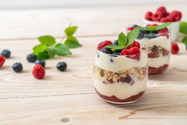 Ev yapımı ahududu ve yaban mersinli yoğurt ve granola. Sağlıklı yemek tarzı.