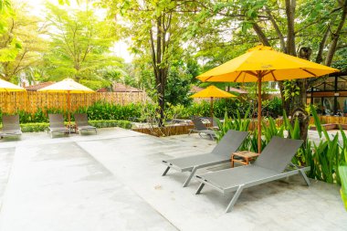 Otelin havuzunda havuz çevresinde şemsiye ve bilardo takımı.