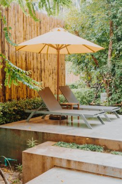 Otelin havuzunda havuz çevresinde şemsiye ve bilardo takımı.