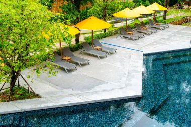 Otelin havuzunda havuz çevresinde şemsiye ve bilardo takımı.