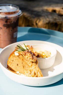 Krem peynirli muzlu kek ve tabakta çörekler.