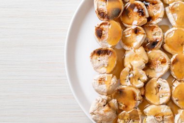 Izgarada dilimlenmiş muz ve karamel sosu.