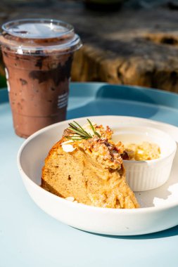 Krem peynirli muzlu kek ve tabakta çörekler.