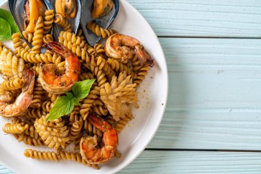 Deniz ürünleri ve fesleğen soslu kızarmış spiral makarna. Füzyon yemek tarzı.