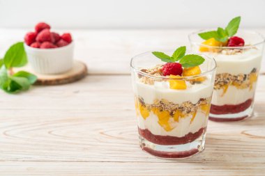 Ev yapımı taze mango ve yoğurt ve granola ile taze ahududu. Sağlıklı yemek tarzı.