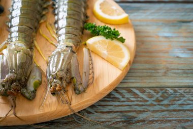 Tahtada limon olan taze peygamber devesi karidesi.