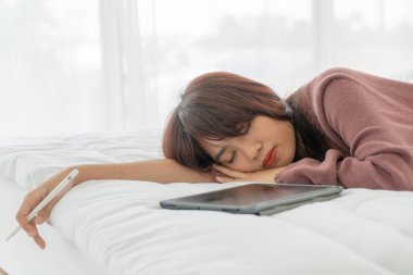 Yatakta tabletle çalışan güzel Asyalı kadınlar
