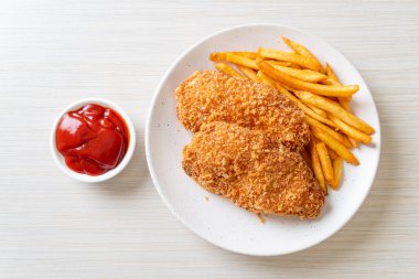 Kızarmış tavuk göğsü fileto biftek yanında patates kızartması ve ketçap.