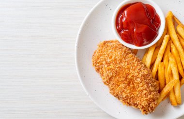 Kızarmış tavuk göğsü fileto biftek yanında patates kızartması ve ketçap.