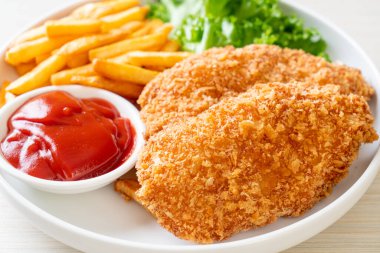 Kızarmış tavuk göğsü fileto biftek yanında patates kızartması ve ketçap.